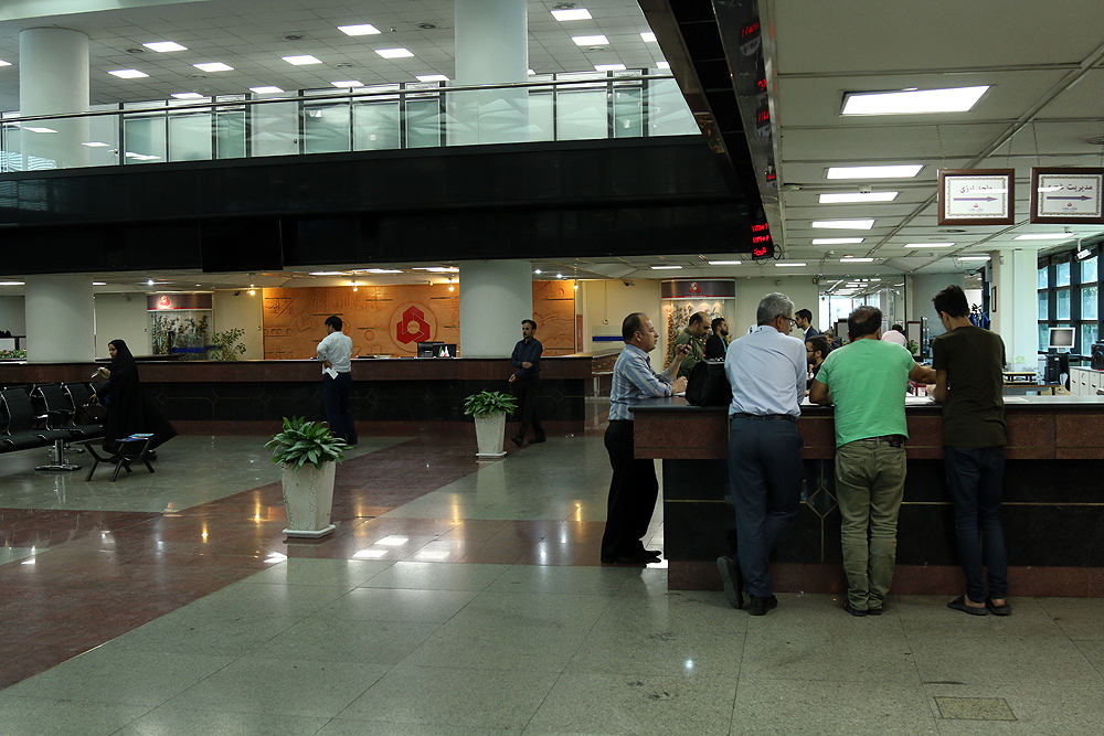  Customers waiting in line to make transactions at a bank.