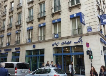 People walk by the Paris branch of Bank Saderat Iran.  