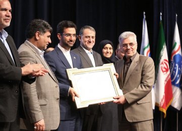 ICT Minister Mohammad Javad Azari-Jahromi (3rd L) presented an award to Hossein Fallah Josheqani, the head of Communications Regulatory Authority, in Tehran on March 12.