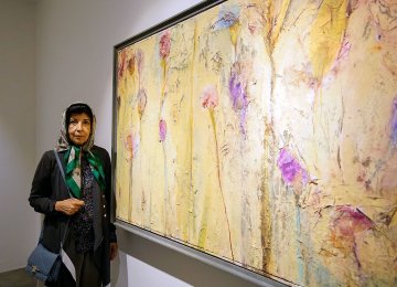 Shirin Ettehadieh standing next to one of her paintings