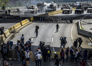 Opposition activists and riot police clash during a protest against President Nicolas Maduro in Caracas.