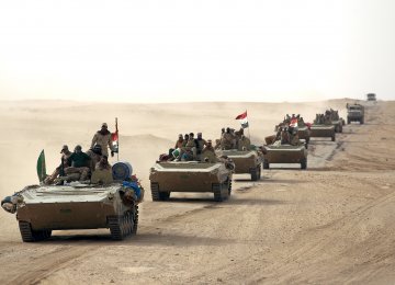 Iraqi forces and members of the Hashed al-Shaabi advance towards the city of al-Qaim, in western Anbar province, as they fight against remnant pockets of IS.