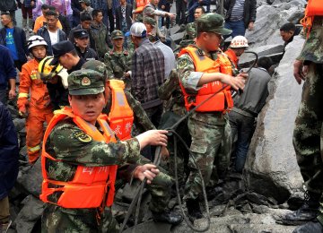 Rescuers search for survivors after a landslide in a mountain village in southwest Sichuan Province, June 24.