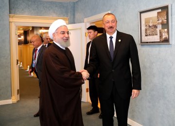 President Hassan Rouhani (L) shakes hands with Azeri President Ilham Aliyev on the sidelines of the Caspian Sea Summit in Kazakhstan on Sunday.