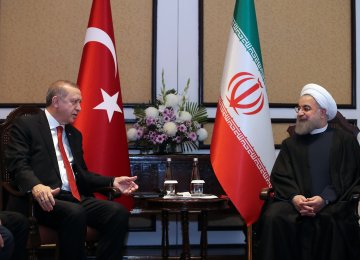 Turkish President Recep Tayyip Erdogan (L) meets his Iranian counterpart, Hassan Rouhani, in Islamabad on March 1.  