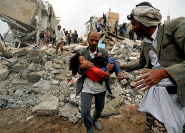 A man carries a five-year-old child rescued from the site of a Saudi-led airstrike that killed eight of her  family members in Sanaa, Yemen, August 25.