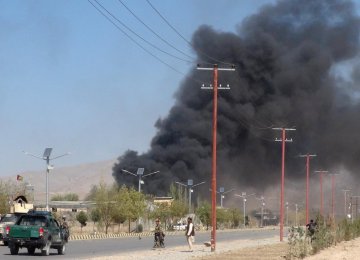 Smoke rises from police headquarters while Afghan security forces keep watch after a suicide car bomber and gunmen attacked the provincial police headquarters in Gardez, the capital of Paktia Province, Afghanistan on October 17.