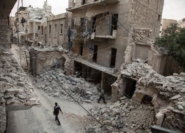 A man walks past destroyed buildings in Aleppo, Syria, in May 2016.