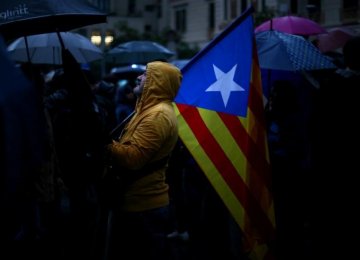 A demonstrator holds an Estelada (Catalan separatist flag) during a gathering in front of the Spanish Central Government headquarters in Barcelona on October 19.