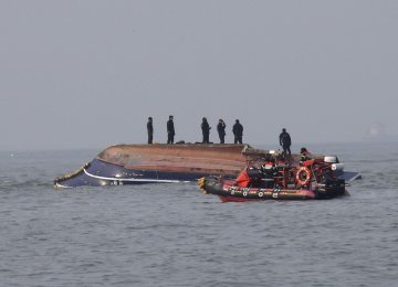 South Korean Coast Guard officers try to rescue a capsized fishing boat which collided with a refueling vessel in the waters off Incheon, South Korea on Dec. 3.