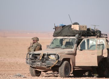 A US fighter stands near a military vehicle in the Syrian city of Raqqa on November 2, 2016.