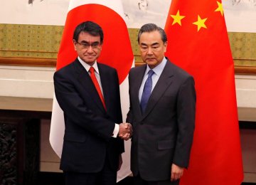 Japanese Foreign Minister Taro Kono (L) and Chinese counterpart, Wang Yi, pose for photograph before their meeting in Beijing on Jan. 28. 