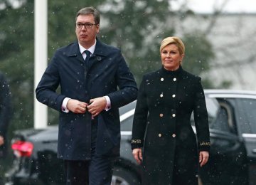 Croatia’s President Kolinda Grabar Kitarovic (R) and Serbia’s President Aleksandar Vucic walk in Zagreb on February 12.