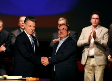 Colombia’s President Juan Manuel Santos and Marxist FARC rebel leader Rodrigo Londono, known as Timochenko, shake hands after signing a peace accord in Bogota, Colombia November 24, 2016.