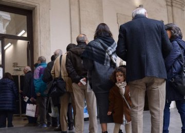 People stand in a queue to cast their ballots in Italy’s municipal elections on June 11, 2017. 
