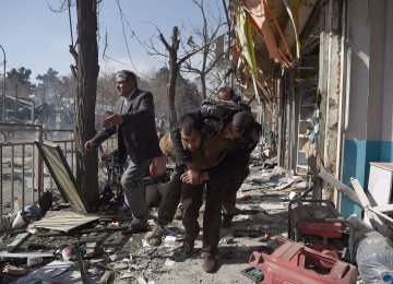 A victim being carried from the site of the bombing in Kabul, Afghanistan, on Jan. 27.  The city’s hospitals were overwhelmed by the number of wounded. 
