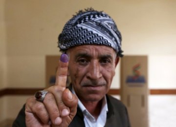 A Kurdish man shows his inked index finger after voting in an independence referendum in Erbil, Iraq on Sept. 25