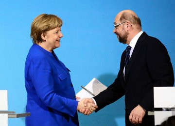 Angela Merkel (L) shakes hands with SPD leader Martin Schulz.