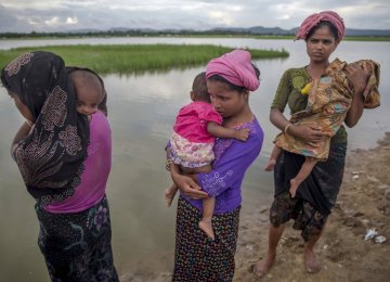 Rohingya Muslim women, who crossed over from Myanmar into Bangladesh,  stand holding their sick children on January 5.