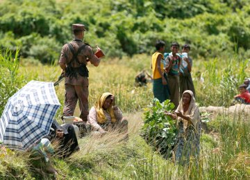 A Rohingya woman urges a member of Border Guard Bangladesh not to turn them back to Myanmar, in Cox’s Bazar, Bangladesh on August 27.