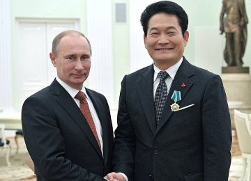 Vladimir Putin (L) and Song Young-gil