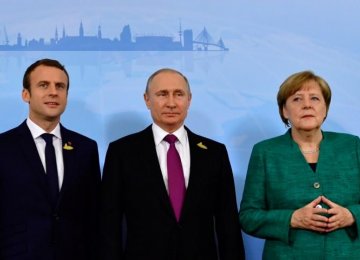 German Chancellor Angela Merkel (R), Russian President Vladimir Putin (C) and French President Emmanuel Macron 