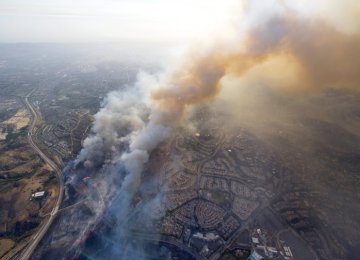 A wildfire moves closer to North Tustin homes along the 261 freeway in Tustin, Calif. on Oct. 9. 