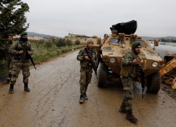 Members of Turkey-backed Free Syrian Army police forces secure the road as they escort a convoy near Azaz, Syria, on Jan. 26.