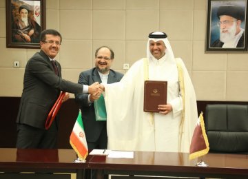 Turkey’s Economy Minister Nihat Zeybekci (L) and his Qatari counterpart Ahmed bin Jassim bin Mohammed Al Thani (R) signed the transportation deal with Iran’s Minister of Industries, Mining and Trade Mohammad Shariatmadari in Tehran on Nov. 26.