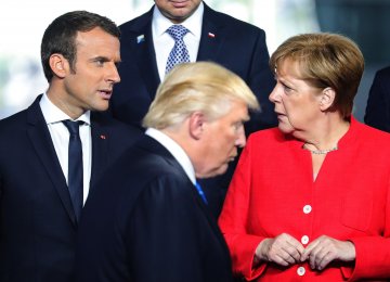 Donald Trump (C) walks past Emmanuel Macron (L) and Angela Merkel on his way to his spot for a family photo during the NATO summit in Brussels, Belgium, on May 25, 2017. (File Photo)