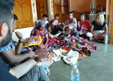 Guests watch artisans making handicrafts in a Gujarati village in India.