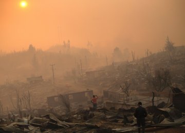 People inspect the remains of their homes after a forest fire in Santa Olga, 240 km south of Santiago. (Photo: Pablo Vera Lisperguer/AFP)