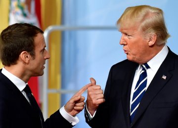 US President Donald Trump has reportedly told French President Emmanuel Macron (L) that he will look for a way to return to the Paris climate accord.
