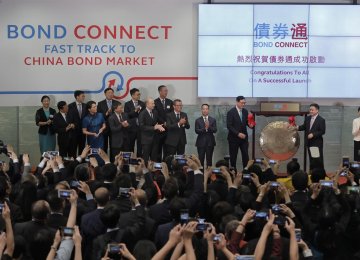 From right, Hong Kong’s new Chief Executive Carrie Lam claps hands as PBoC Deputy Governor Pan Gongsheng and Hong Kong Monetary Authority Chief Executive Norman Chan beat a gong to launch the Bond Connect in Hong Kong, July 3.