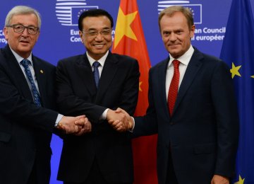 Chinese Premier Li Keqiang (C) shakes hands with Jean-Claude Juncker (L) and Donald Tusk after the meeting in Beijing on Monday.