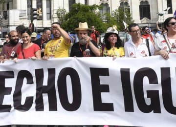 Demonstrators march in Madrid behind a banner reading “bread, work, homes and equality”.