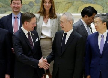 Chinese Vice-Premier Liu He and Jyrki Katainen shake hands after a group photo event at the  Diaoyutai State Guesthouse in Beijing on Monday.
