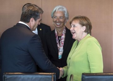 Angela Merkel (R) welcomes Christine Lagarde (C) and Roberto Azevedo for a meeting at the chancellery in Berlin on Monday.