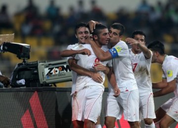 Iranian players rejoice after scoring a goal.