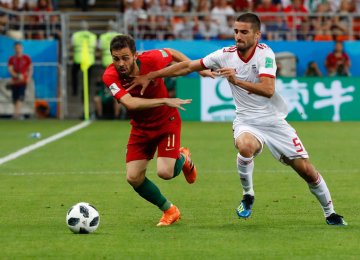 Milad Mohammadi (R) vies for the ball with Bernardo Silva during Iran-Portugal match in FIFA World Cup Russia.