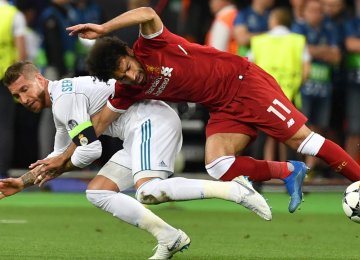  Mohamed Salah (R) goes down after a challenge from Real Madrid’s Sergio Ramos.