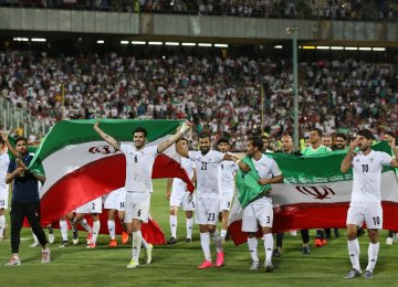 Iranian players celebrate after winning the 2018 World Cup qualifying football match against Uzbekistan at Azadi Stadium in Tehran on June 12.