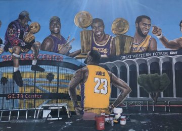 The mural in LA shows LeBron James looking up at several Lakers stars and  its historic venues.