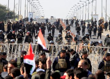 Riot police stand in front of demonstrators during the protest near Baghdad’s Green Zone on Feb. 11.