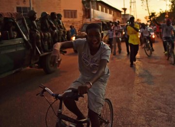 A boy rides a bike near a Senegalese vehicle, as ECOWAS soldiers arrive at the statehouse in Banjul.