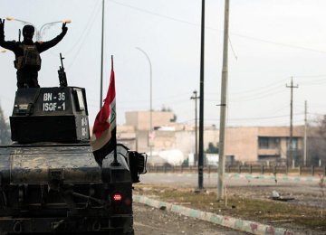 An Iraqi soldier rides an armored vehicle in Mosul.