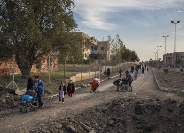 Iraqi families flee east Mosul through the recently liberated Mosul University complex.