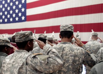 Soldiers salute the US flag.