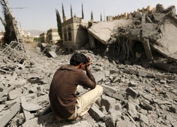 Man sits on the rubble after a Saudi-led coalition airstrike.