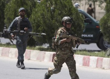 Afghan security personnel get into position at the site  of an attack on the Interior Ministry in Kabul on May 30.